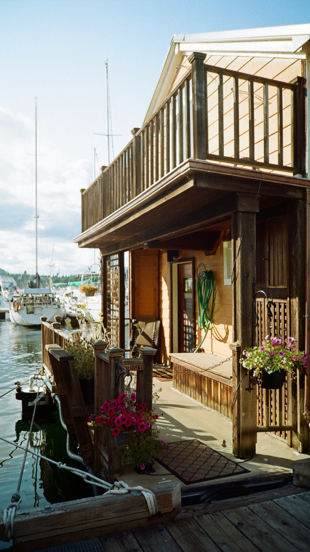 Wooden float home on a dock with hanging flower baskets