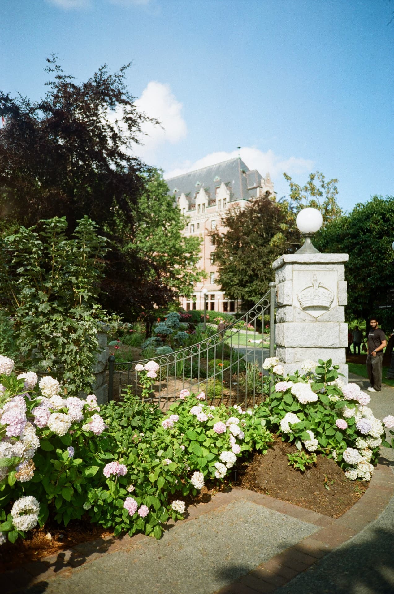 Hydrangeas at a stone gate with a heritage hotel behind